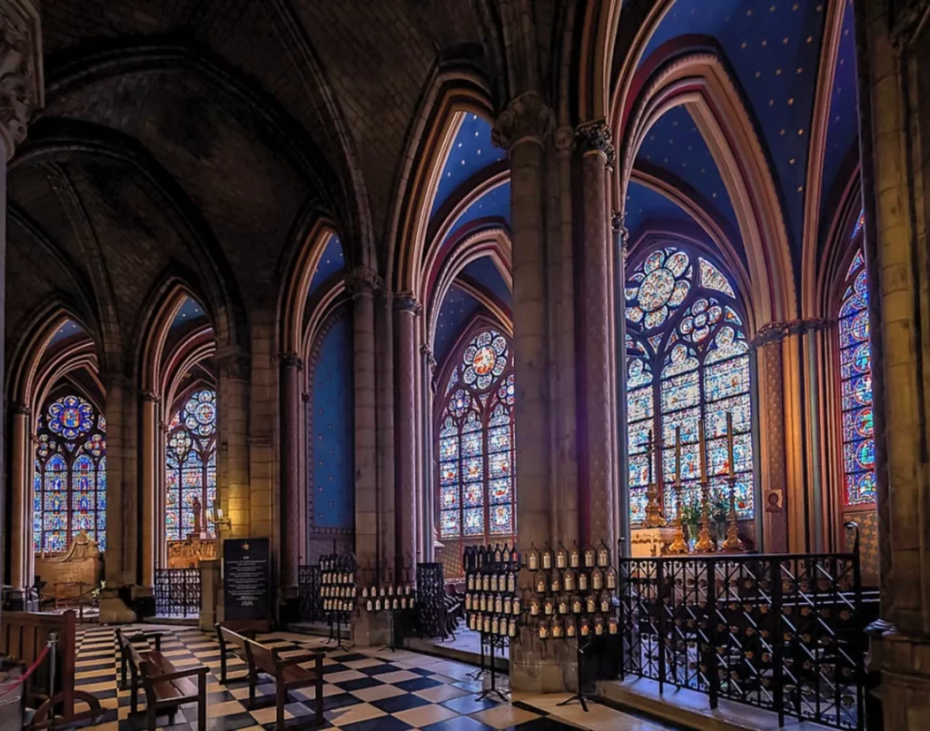 Interior da Catedral de Notre-Dame de Paris com naves góticas, colunas de pedra e vitrais coloridos medievais