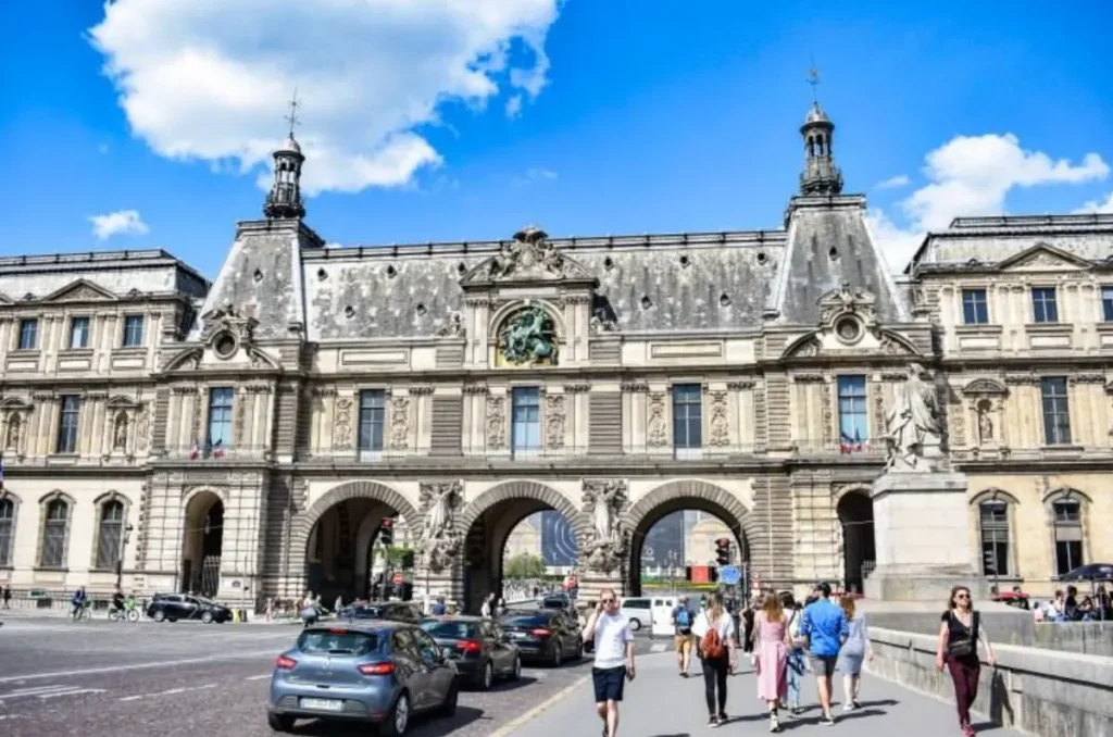 Arquitetura monumental do Louvre em uma movimentada paisagem urbana de Paris.