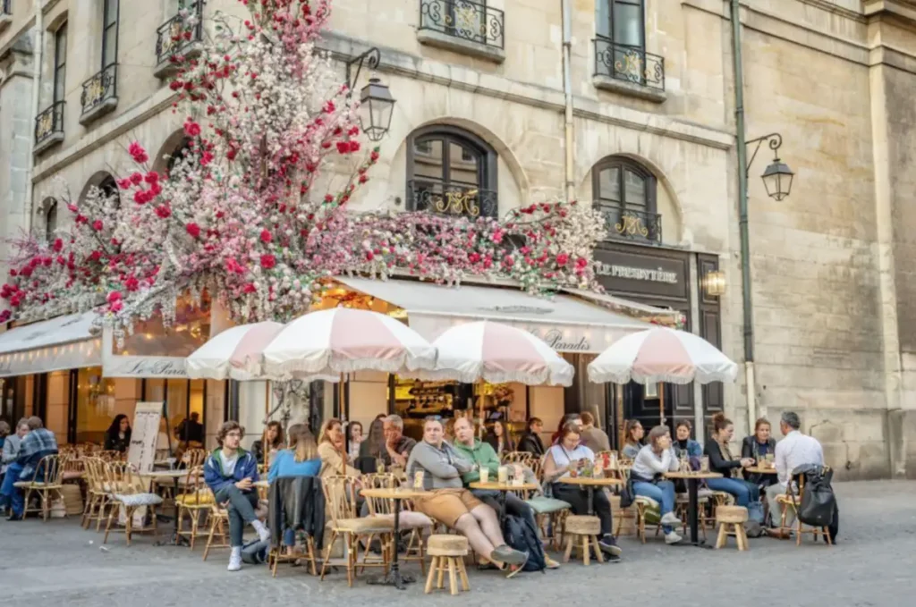 O charme dos cafés de Paris em um terraço florido, perfeito para aproveitar a cidade ao ar livre.