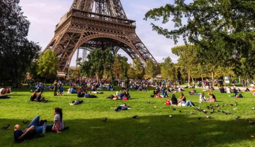 Parisienses e visitantes aproveitam o gramado do Champ de Mars aos pés da Torre Eiffel.